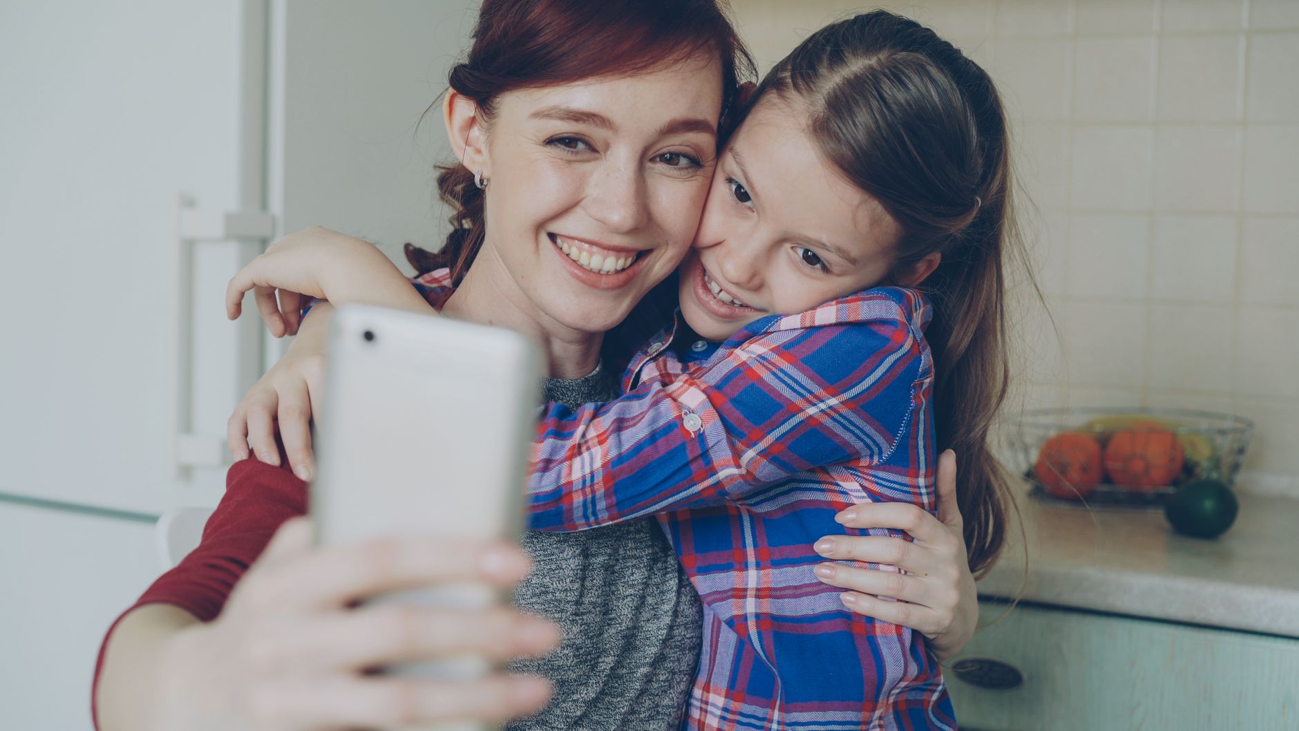 Osoba robi sobie selfie smartfonem w domu i sprawdza zdjęcie na ekranie
