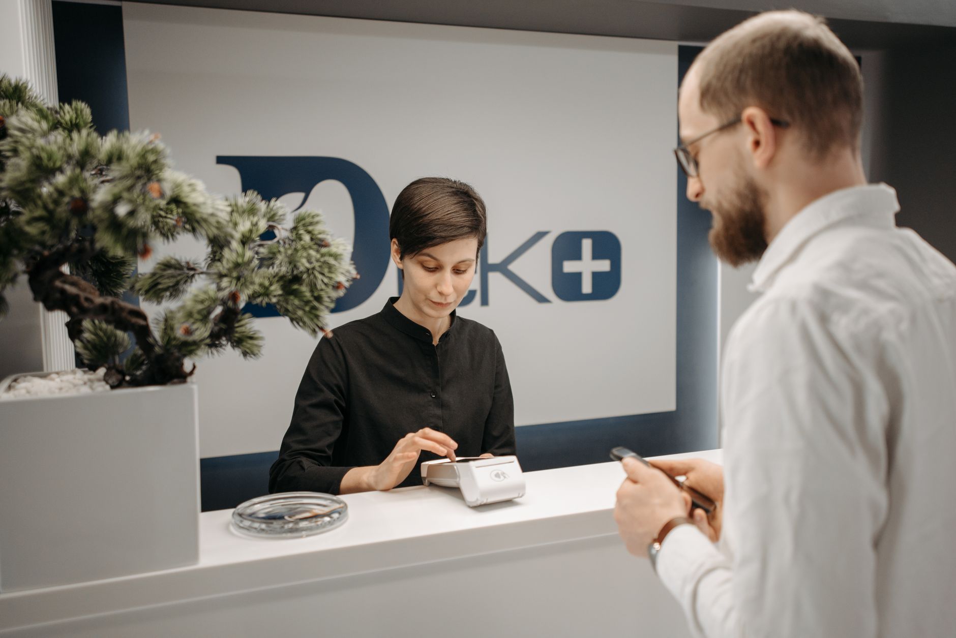 Rejestracja w powiatowym centrum zdrowia — pracownica przekazuje formularz pacjentowi
